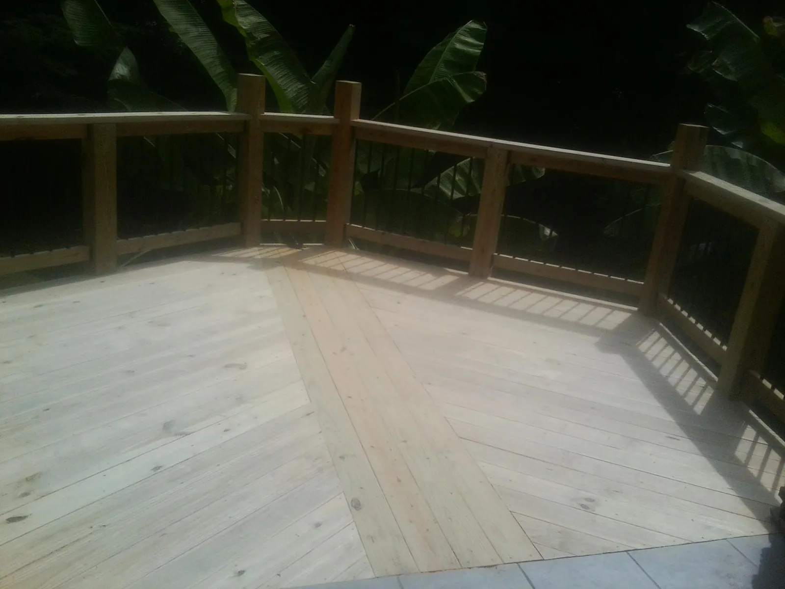 New wood deck and railing built off the back of a home in Manilla