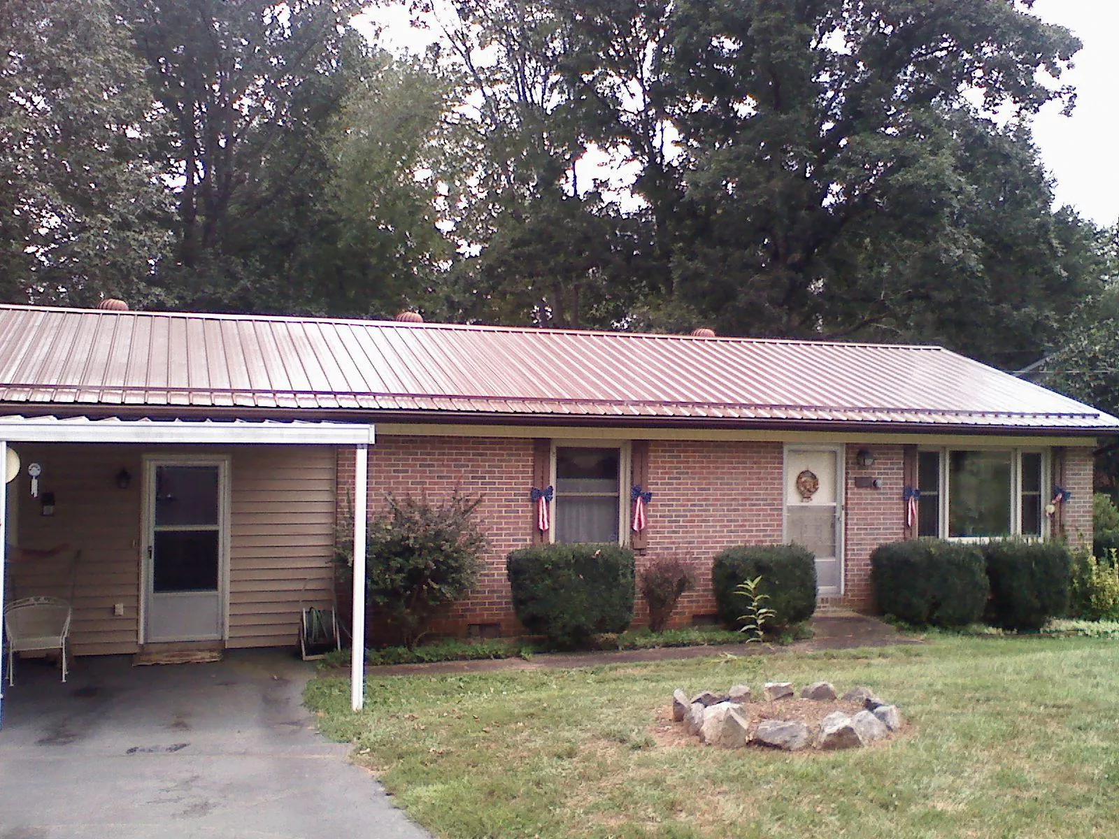 Bronze metal roof and carport on a brick ranch home — Roof Repair work by our crew in Manilla